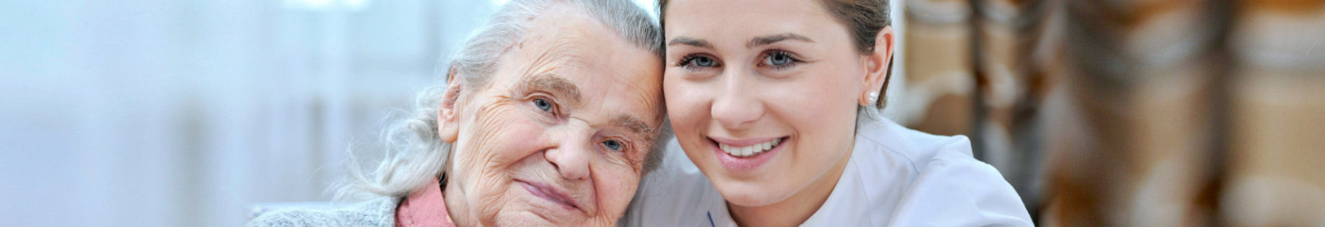 senior woman and caregiver smiling